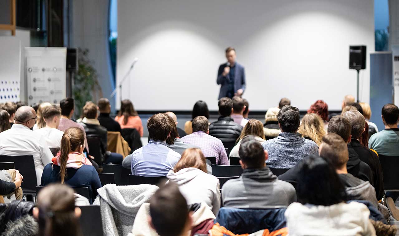 speaker-giving-talk-conference-hall-business-event-audience-conference-hall